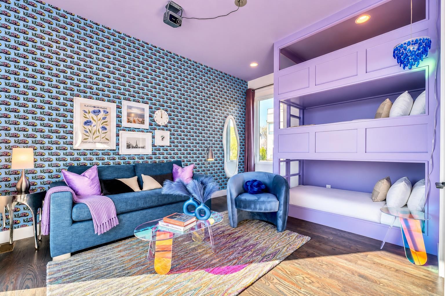 Bedroom with a lavender built-in bunk bed, blue seating, and colorful patterned wallpaper.