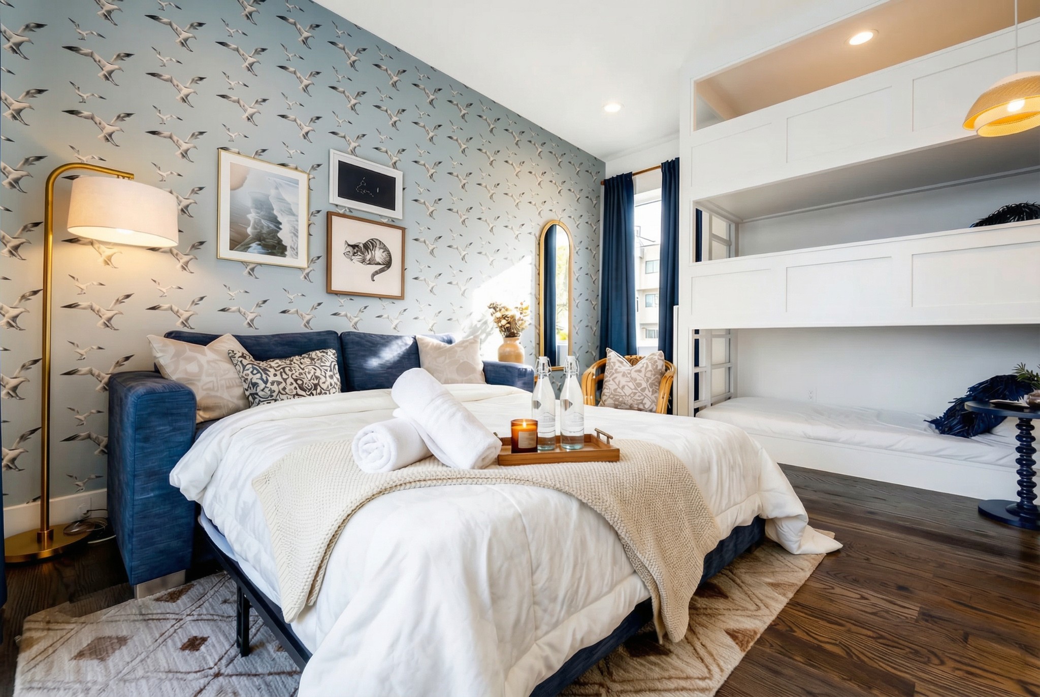 Furnished bedroom with bird-patterned wallpaper, a white bed, and built-in bunk beds.