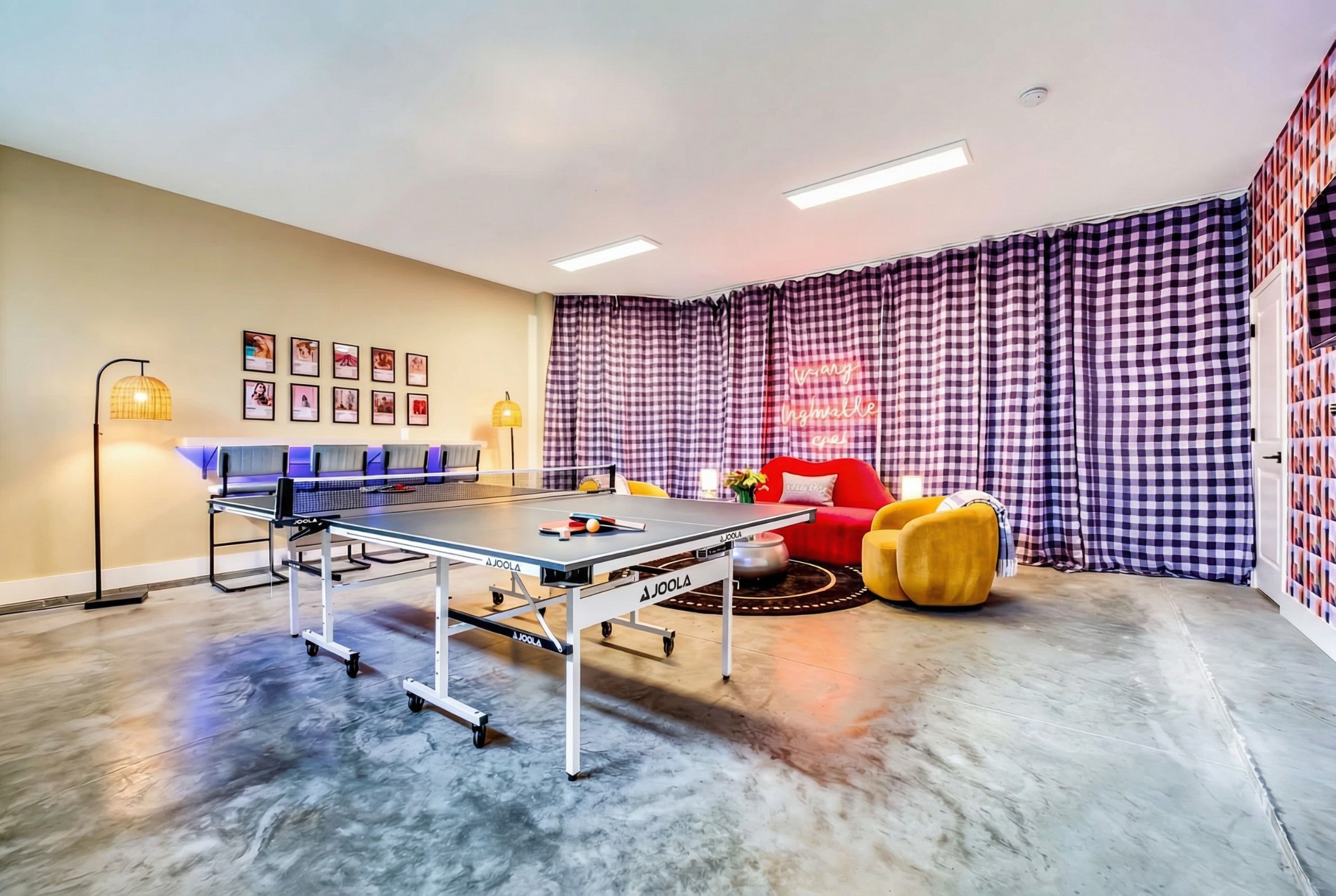 Recreation room with a ping-pong table, checked curtains, and colorful lounge seating.