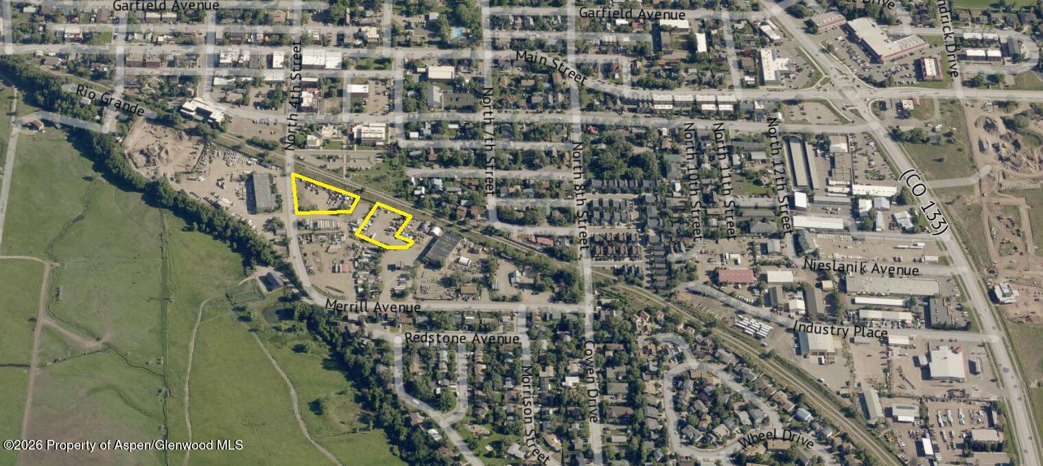 Aerial view of two yard-storage parcels outlined in yellow beside Merrill Avenue, with homes and industrial lots nearby.