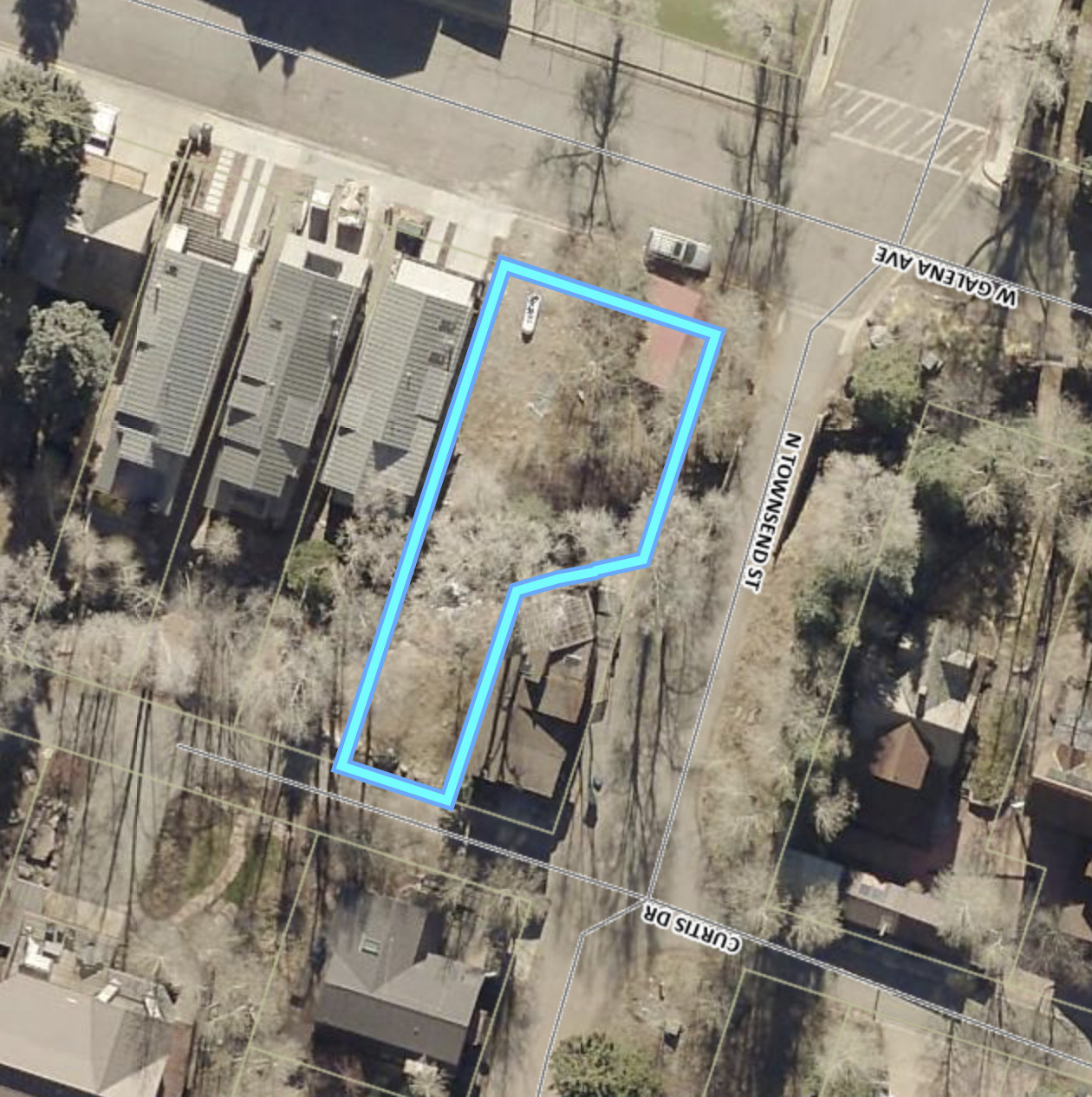Aerial view of a mostly wooded parcel outlined in blue beside N Townsend Street.