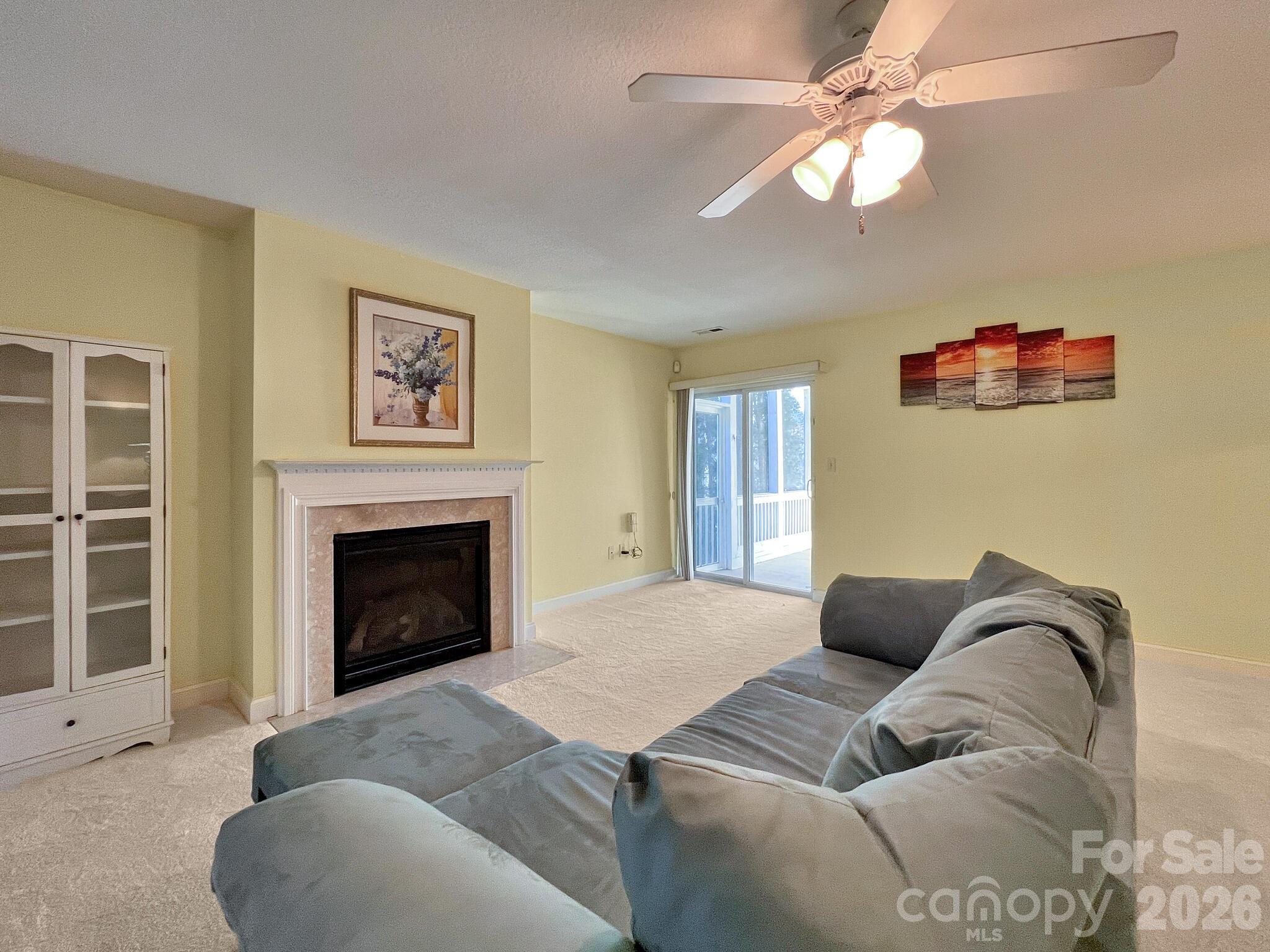 Living room with a gray sectional sofa, fireplace, and sliding glass door to a deck.