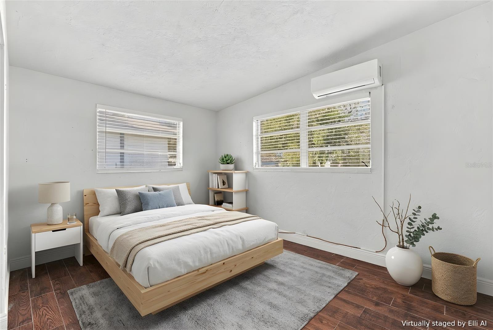 Virtually staged bedroom with a light wood bed, two blinded windows, and a wall-mounted air conditioner.