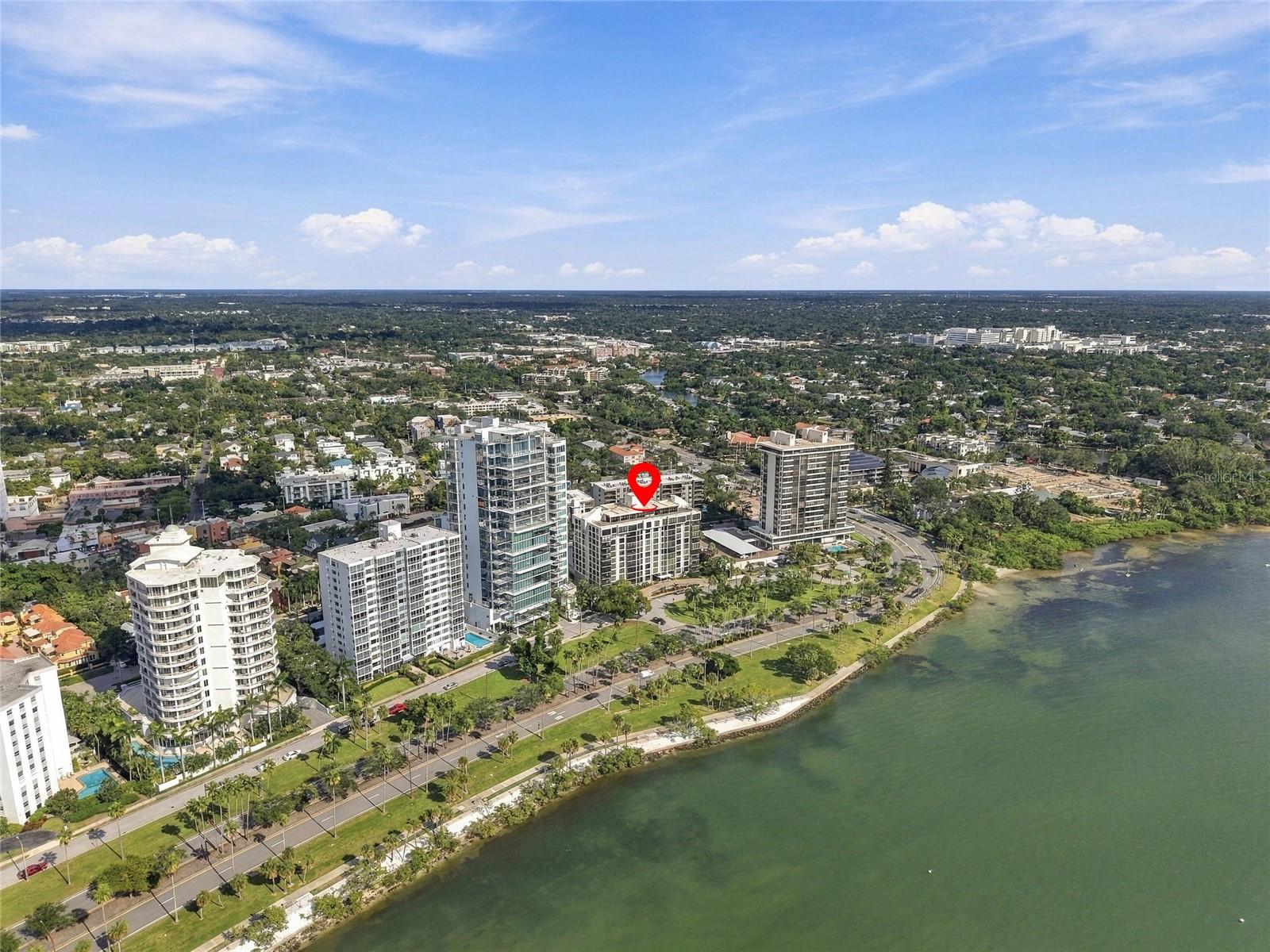 Aerial view of a waterfront condominium in Sarasota, marked with a red location pin.
