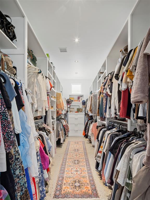 Walk-in closet with built-in clothing storage and a patterned runner.