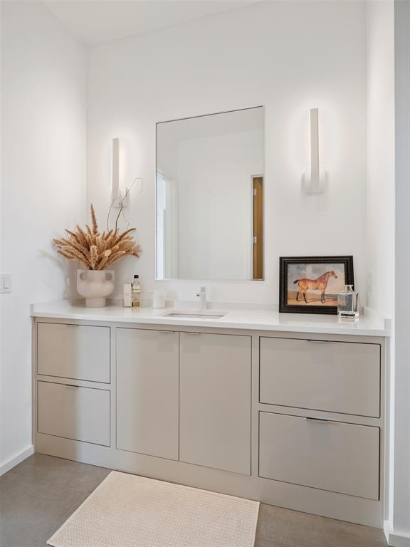 Modern bathroom vanity with a large mirror, wall sconces, and framed horse picture.