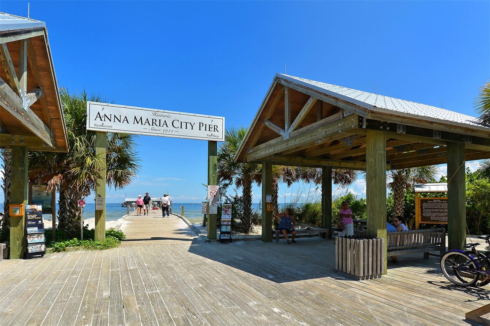Anna Maria City Pier entrance with timber pavilions and a boardwalk extending toward the water.