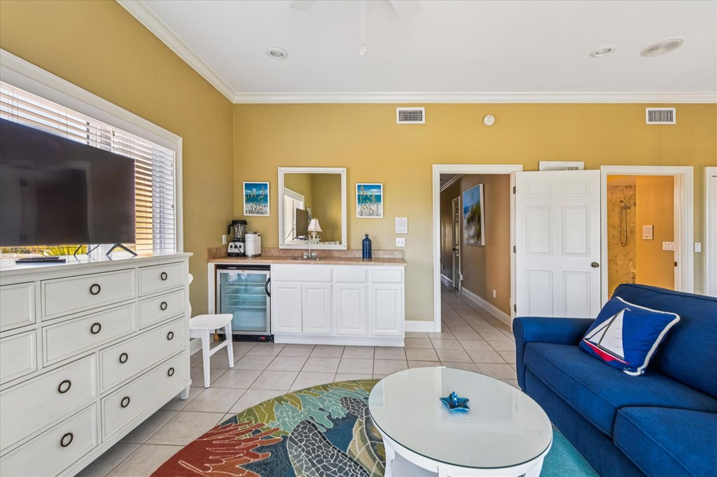 Living room with a blue sofa, built-in beverage bar, and colorful area rug.