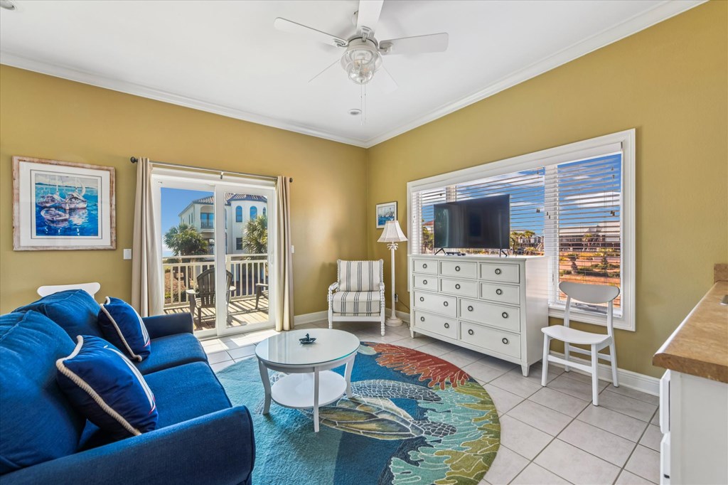 Living room with a blue sofa, television, and sliding glass doors to a balcony.