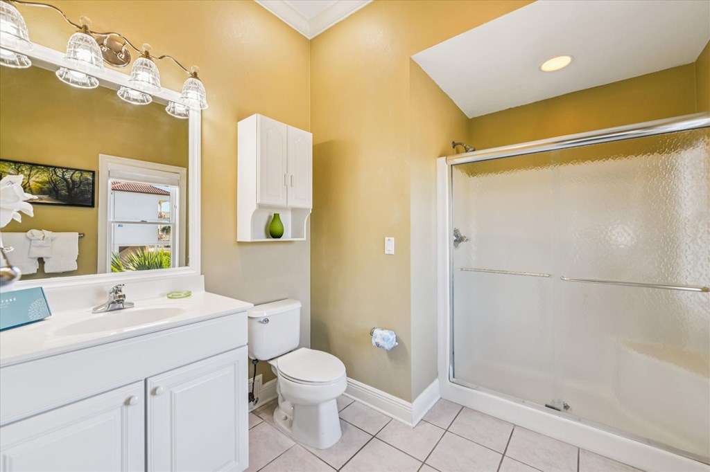 Bathroom with a white vanity, toilet, and glass-enclosed tub and shower.