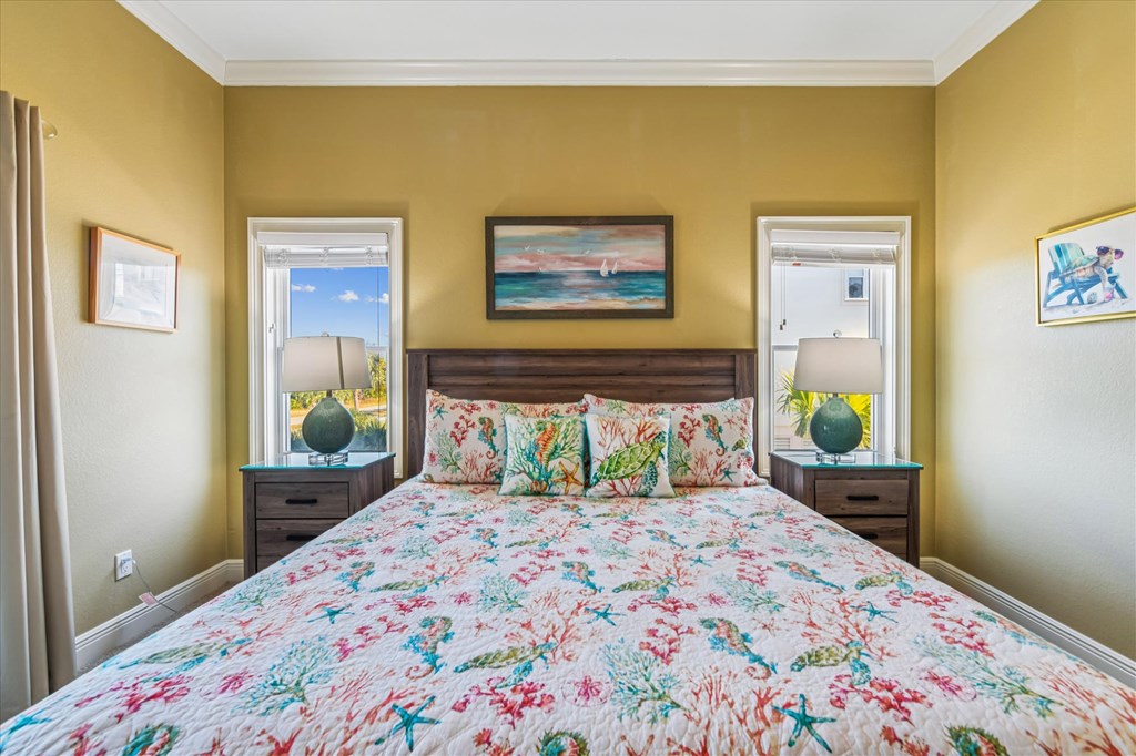 Bedroom with a colorful floral quilt, dark wood headboard, and mustard yellow walls.
