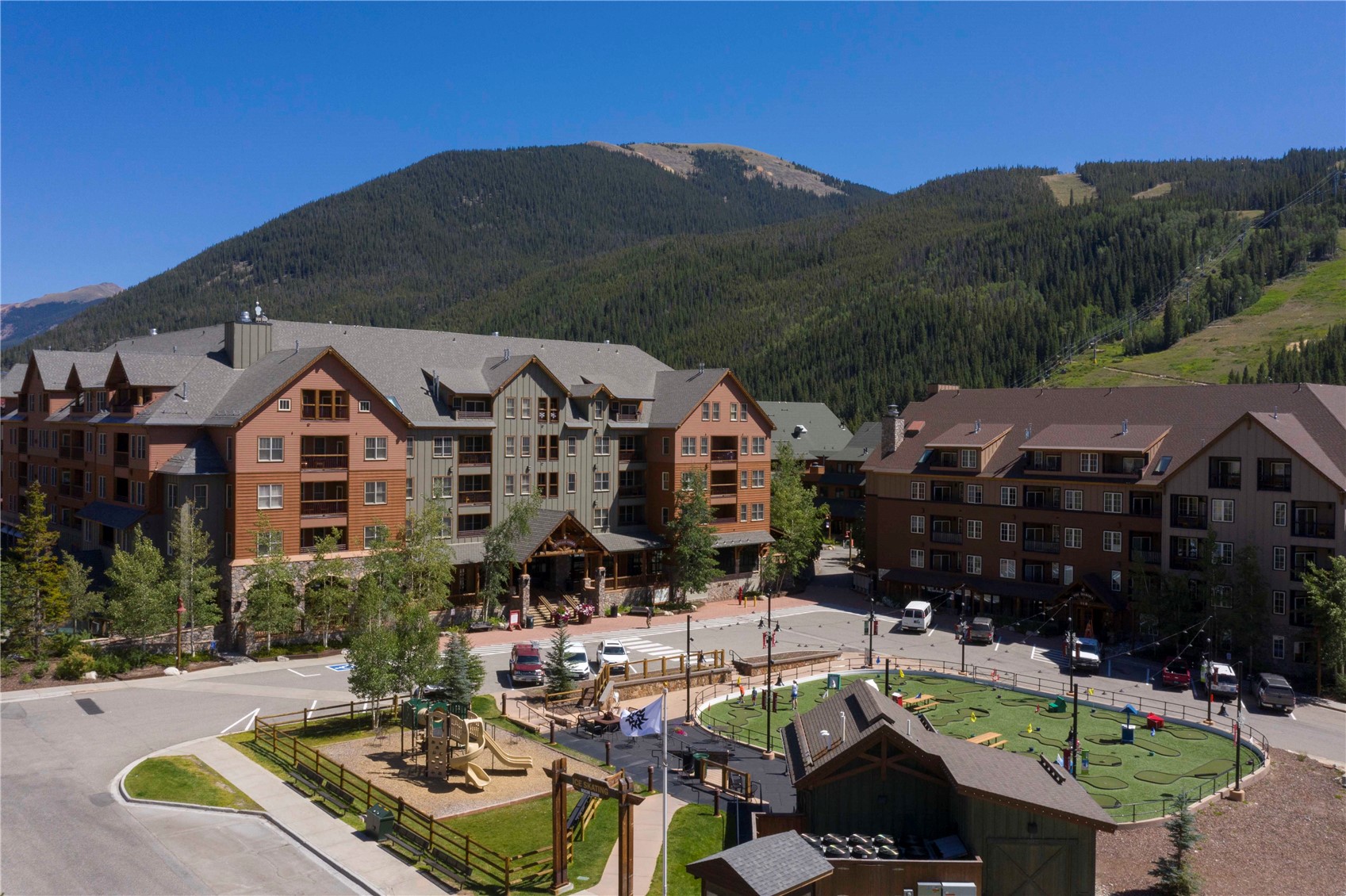 Keystone condominium buildings with a forested mountain backdrop and miniature golf course.