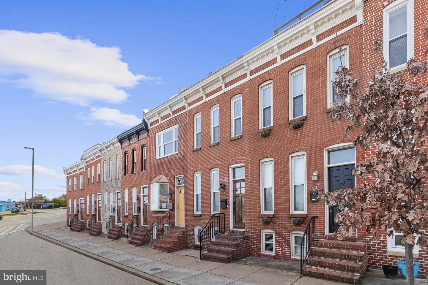 Red-brick Baltimore rowhomes with front steps and black railings; 659 is near the center.