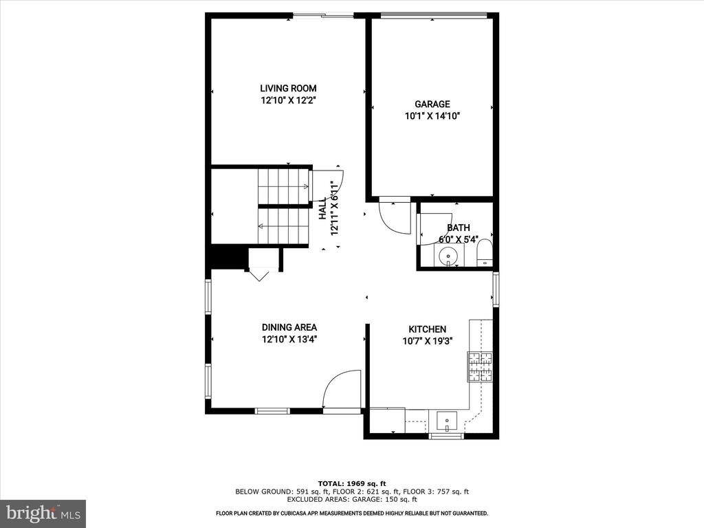 Floor plan showing the living room, dining area, kitchen, bath, garage, hall, and staircase.