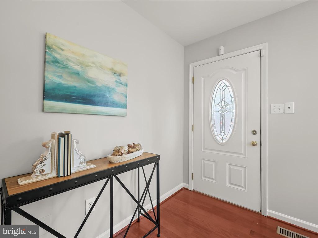 Entryway with a glass-inset front door, console table, and blue-green abstract artwork.