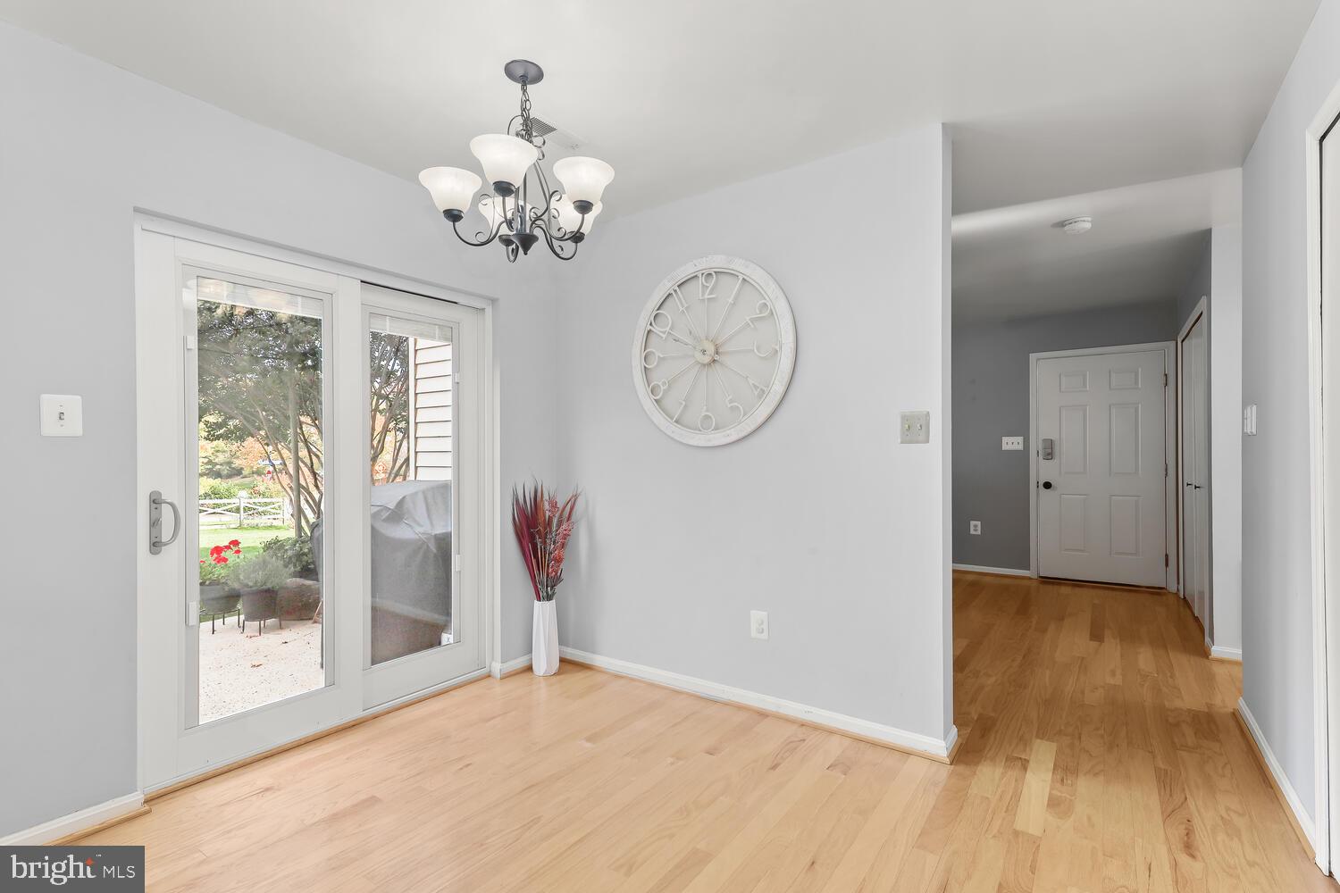 Dining area with light wood floors, a chandelier, and sliding glass doors to a patio.
