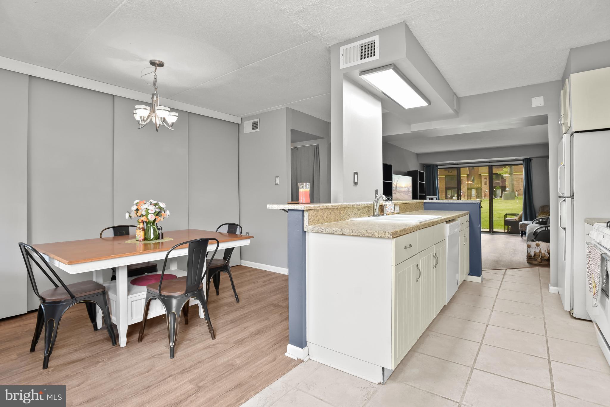 Open-plan kitchen and dining area with a peninsula island and sliding doors to a lawn.