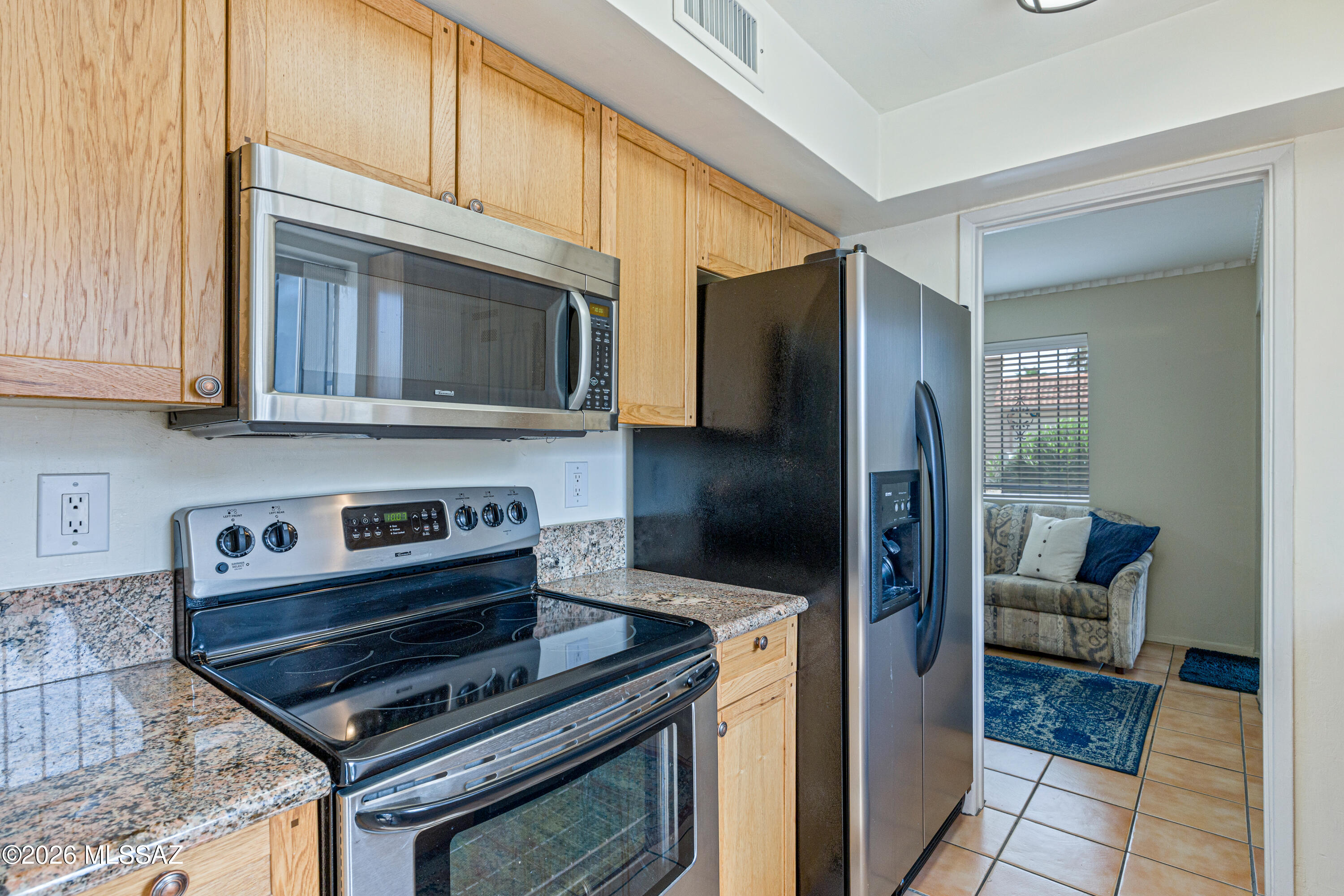 Kitchen with wood cabinets, granite counters, and stainless steel appliances.