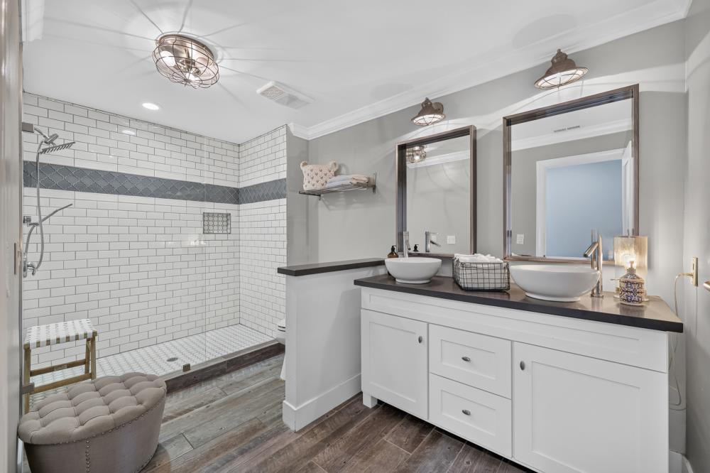 Bathroom with a tiled walk-in shower and double vanity with vessel sinks.
