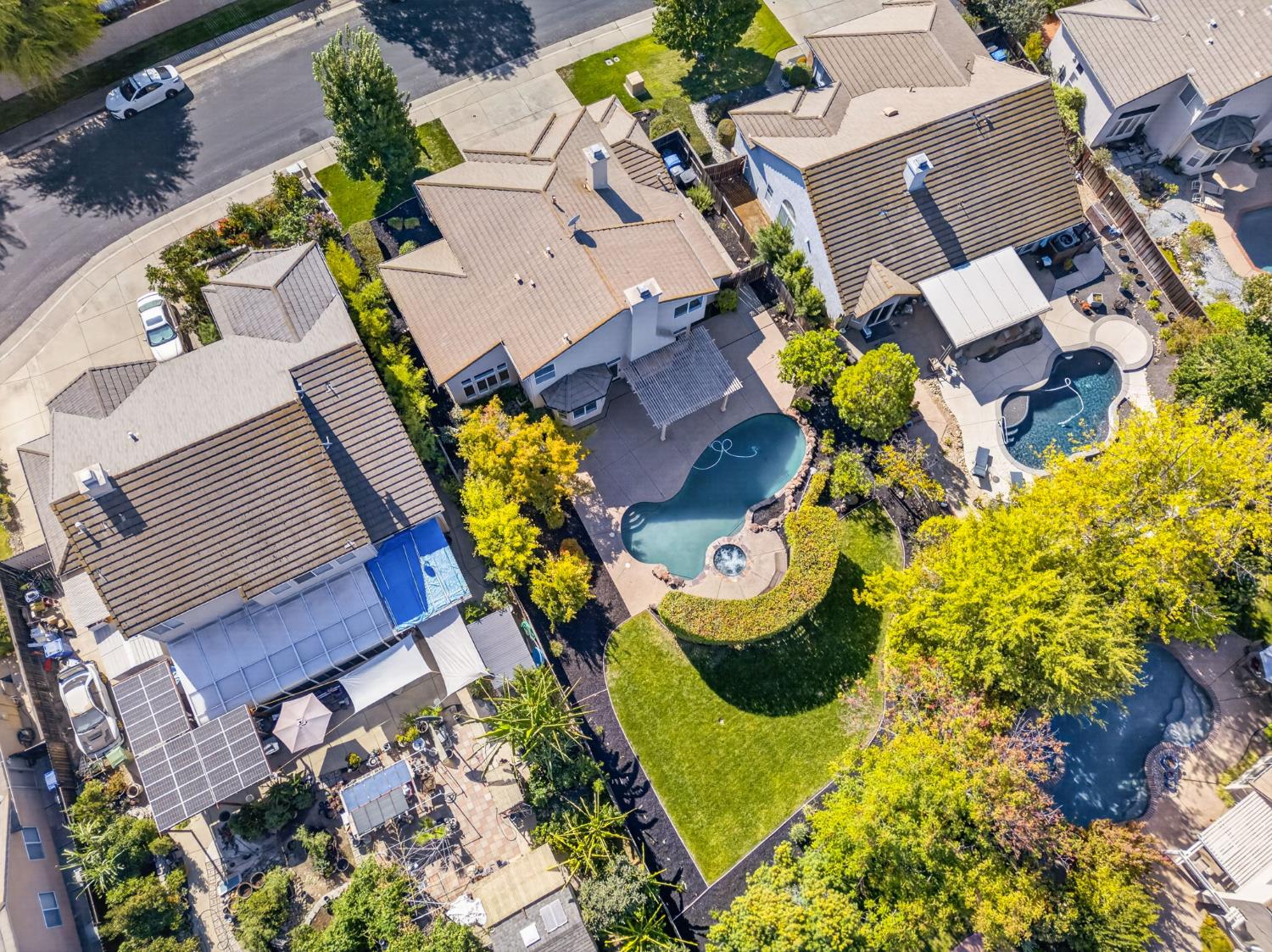 Aerial view of a home with a freeform pool and landscaped backyard.