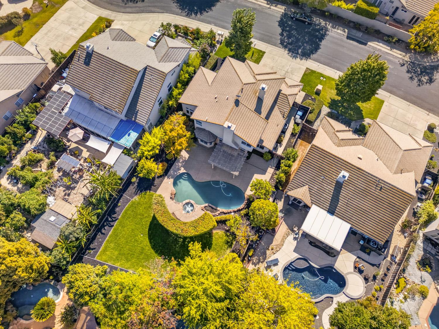 Aerial view of a home with a landscaped backyard and swimming pool.