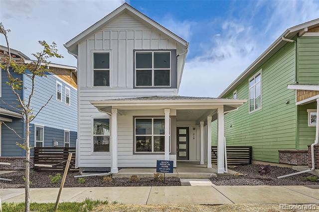 Two-story gray home with a covered front porch between blue and green neighboring houses.