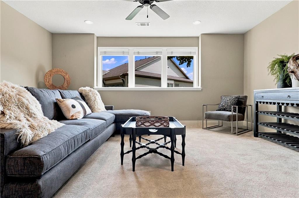 Staged living room with a gray sectional, black coffee table, and wide window.