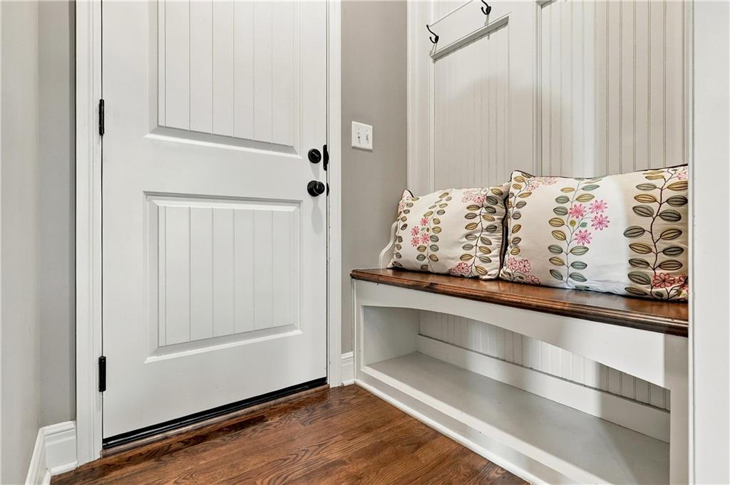 Entryway with a white paneled door and built-in bench topped with floral cushions.