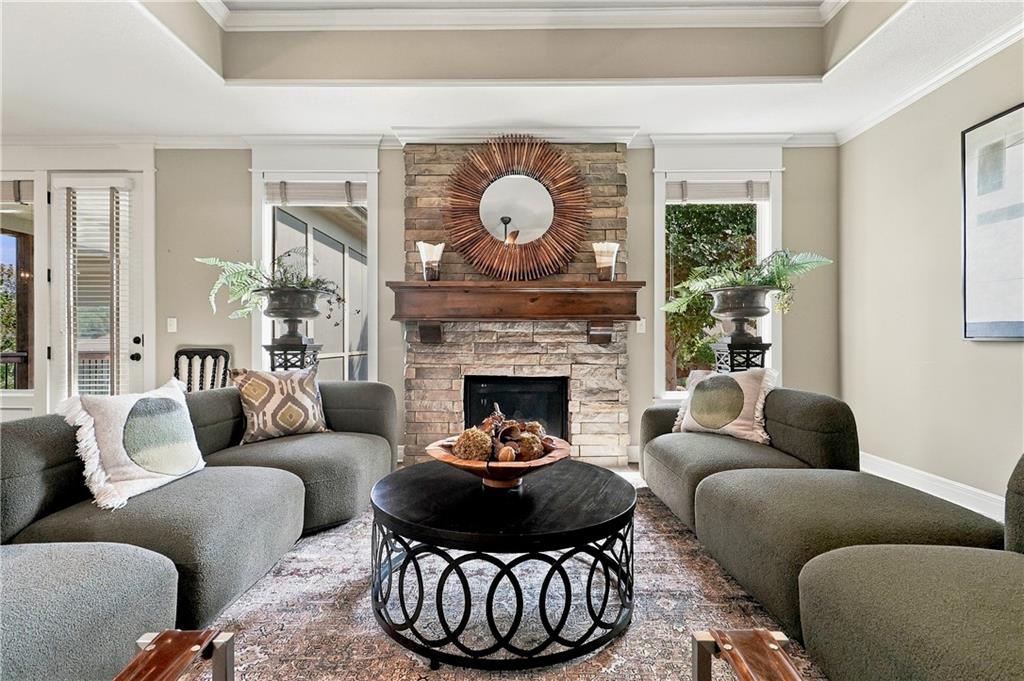 Living room with gray sofas, a round black coffee table, and a stone fireplace.
