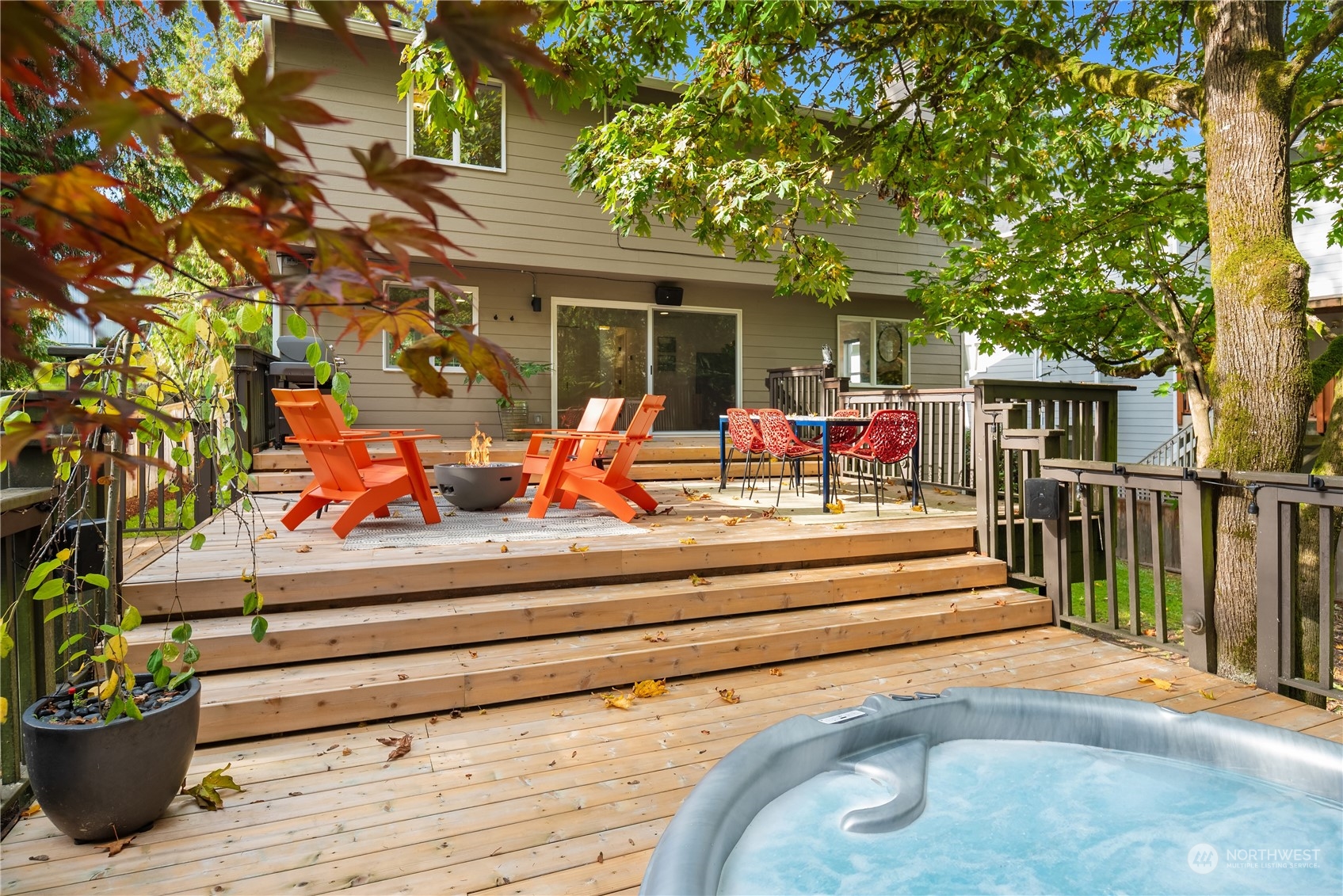 Back deck with orange Adirondack chairs, a fire bowl, and an inflatable hot tub.
