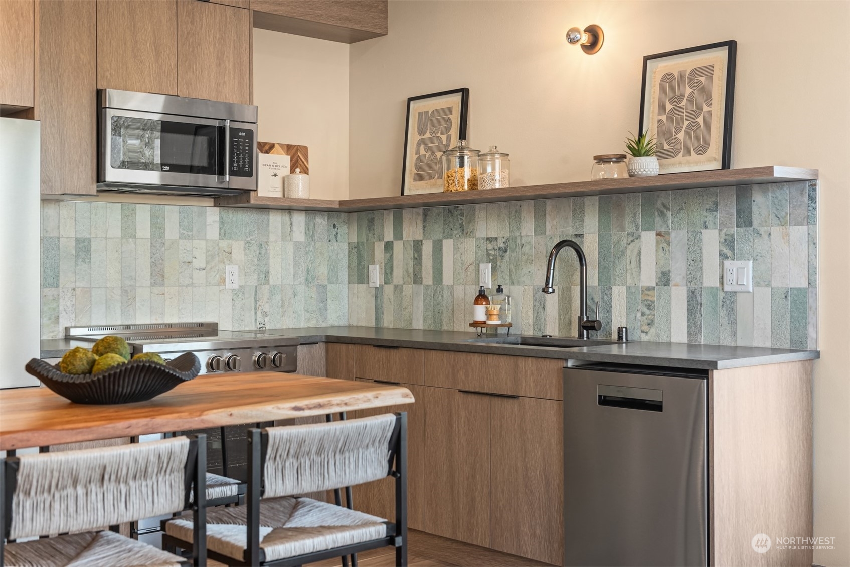 Modern kitchen with warm wood cabinets, a multicolored tile backsplash, and a dining table.