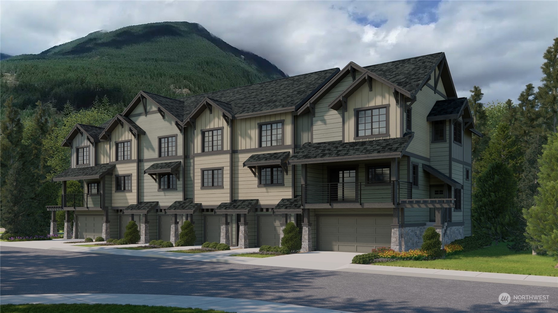 Attached mountain homes with garages and balconies, backed by a forested mountain.