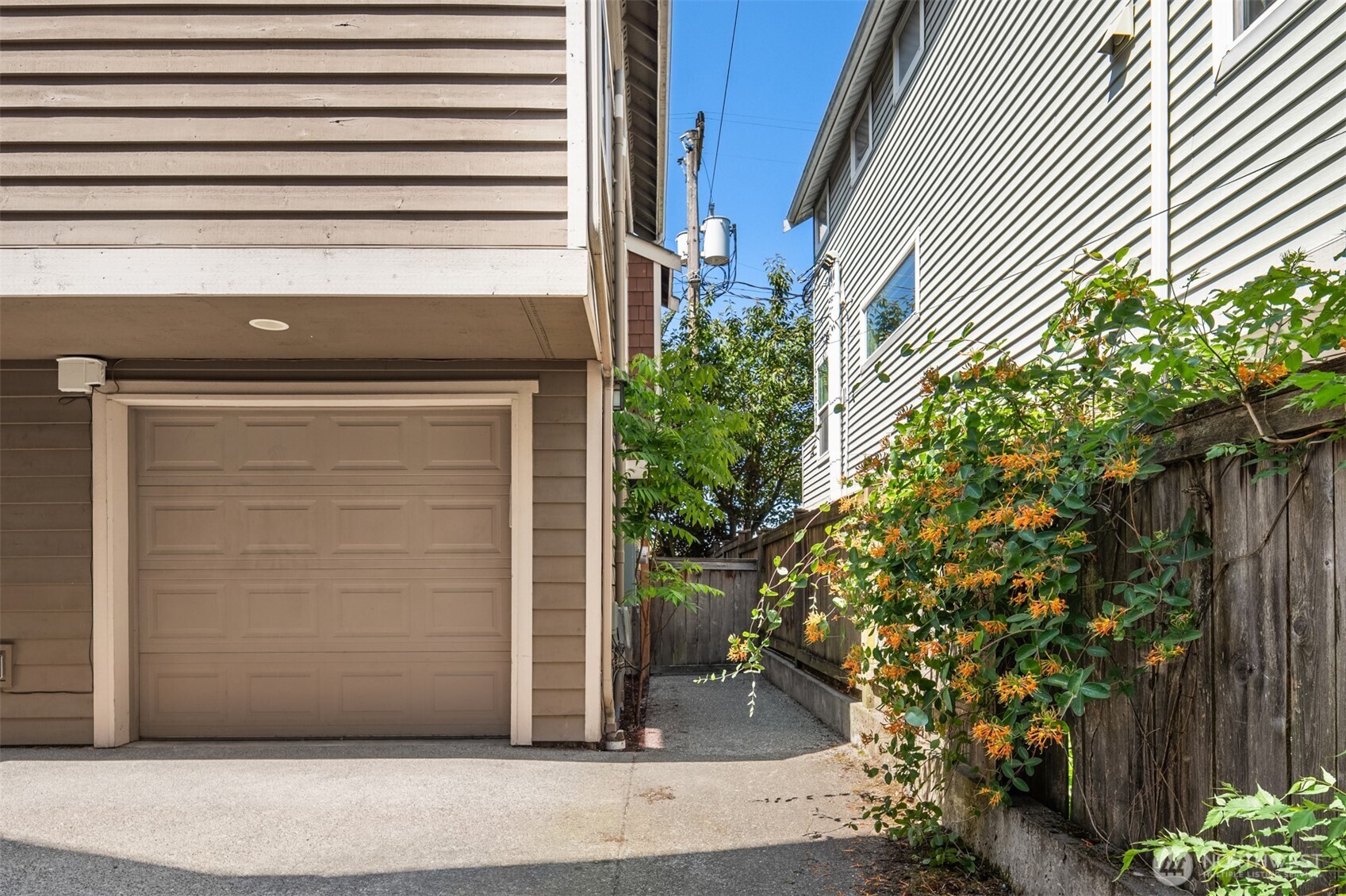 Home exterior with attached garage and a flower-lined side passage.