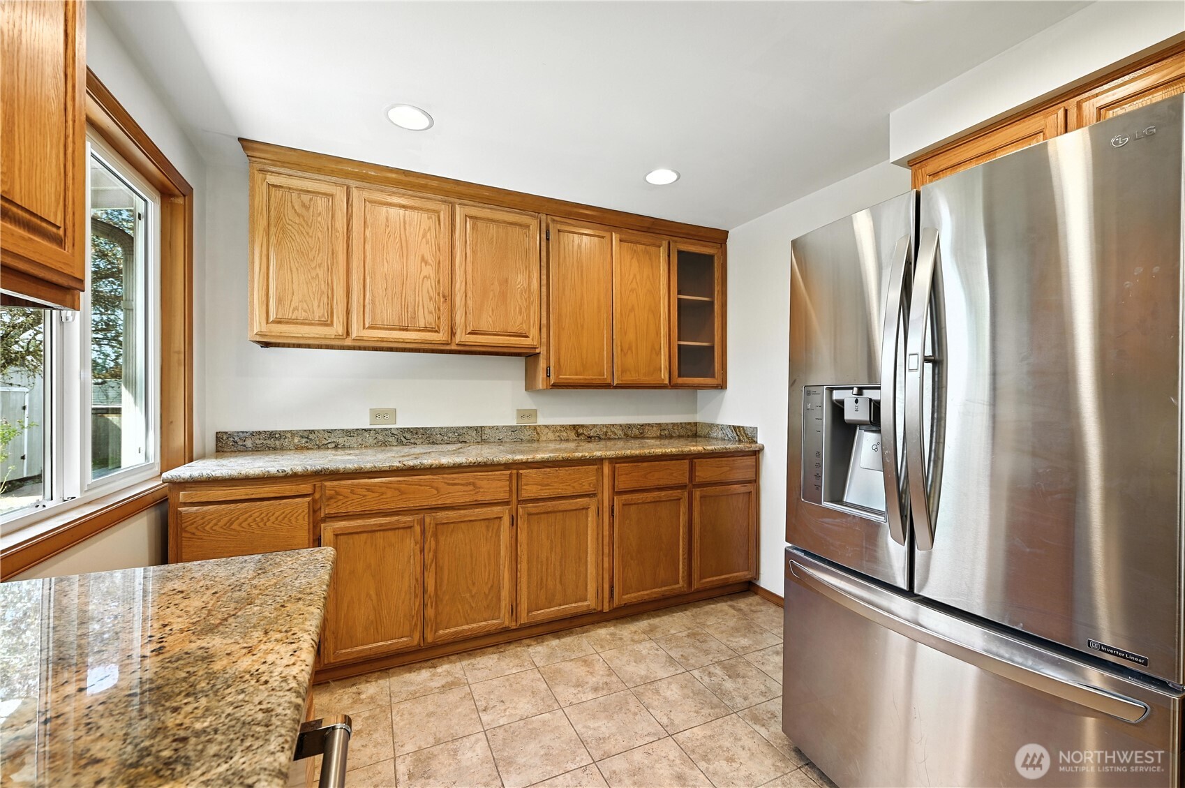 Kitchen with wood cabinets, granite countertops, and a stainless steel French-door refrigerator.