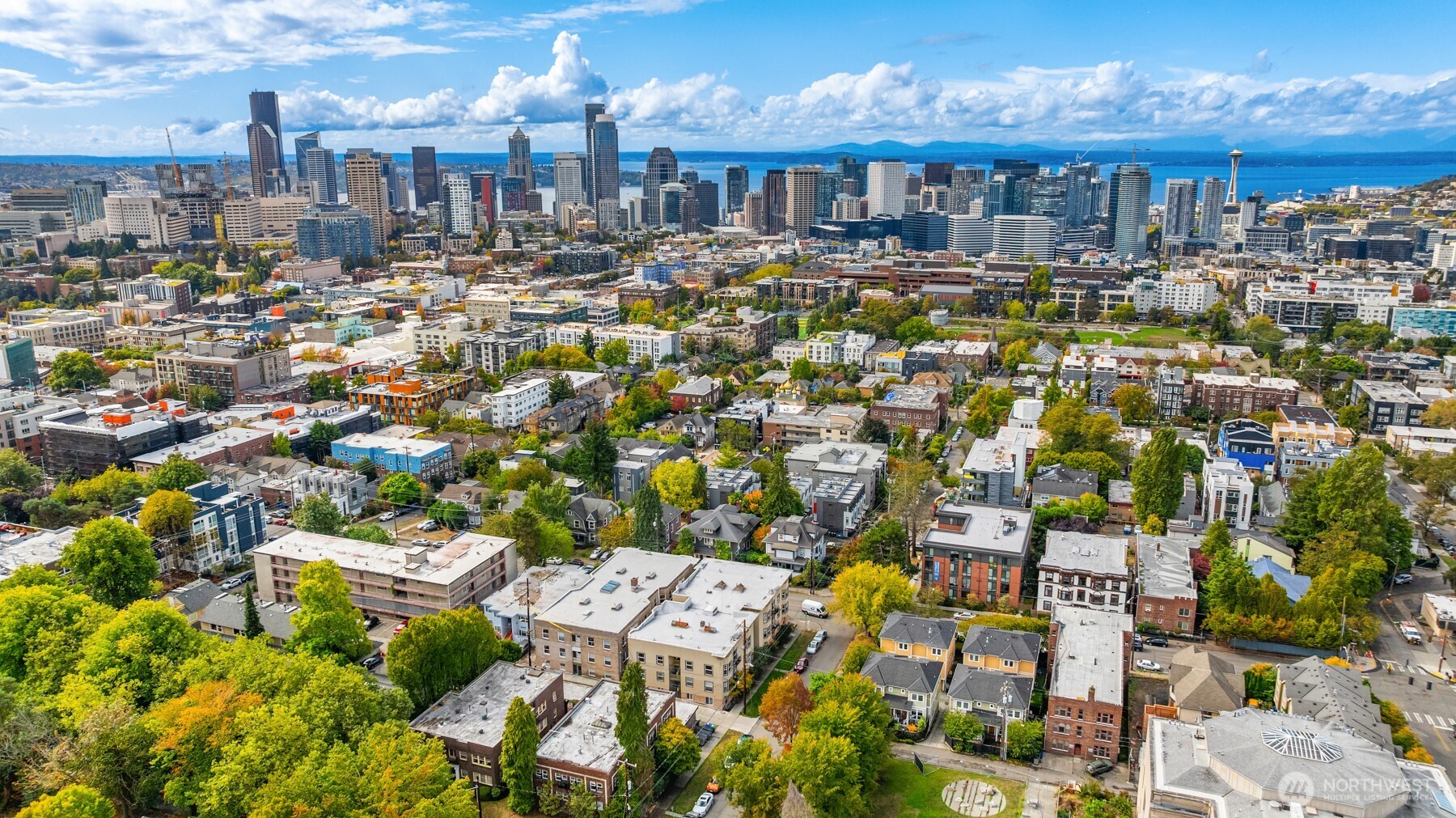 Aerial view of Seattle, with the downtown skyline, Space Needle, and Puget Sound in the distance.