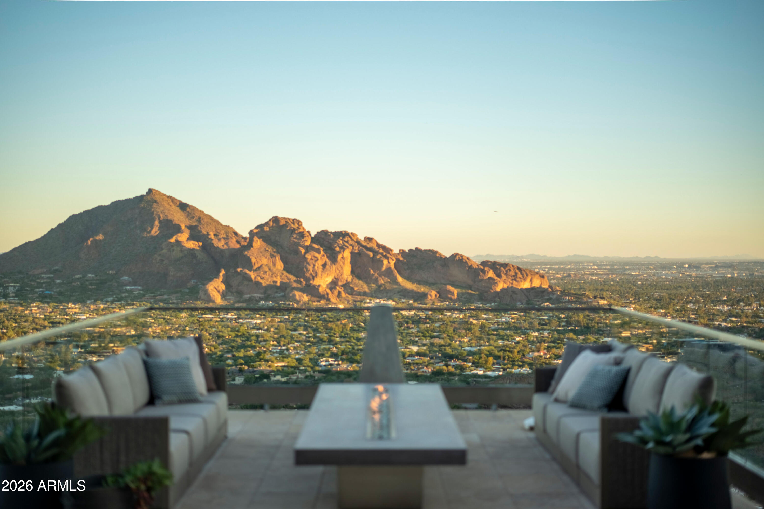 Furnished terrace overlooking Camelback Mountain and the Scottsdale cityscape at golden hour.