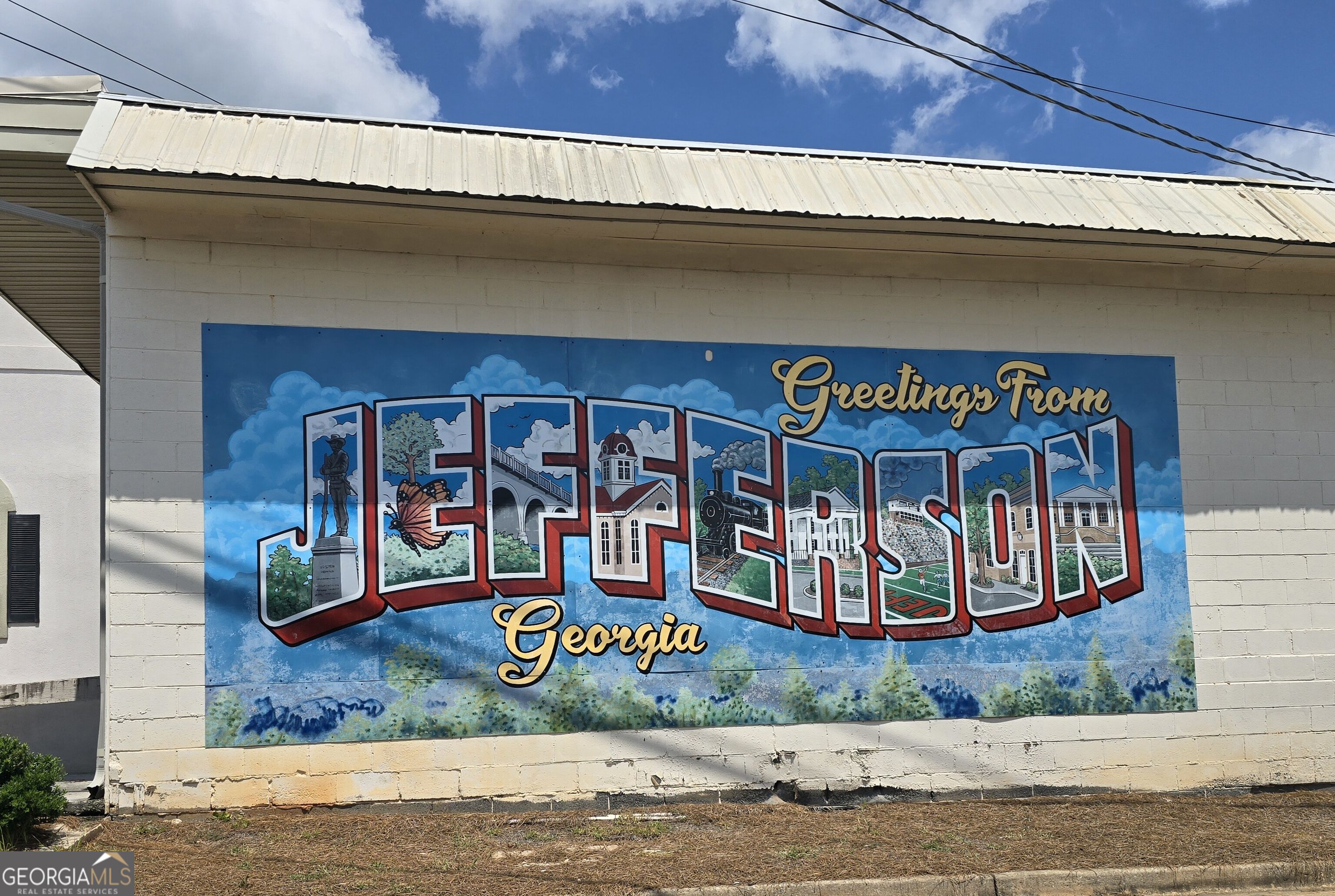 Jefferson, Georgia mural featuring illustrated local landmarks and the words “Greetings From Jefferson Georgia.”