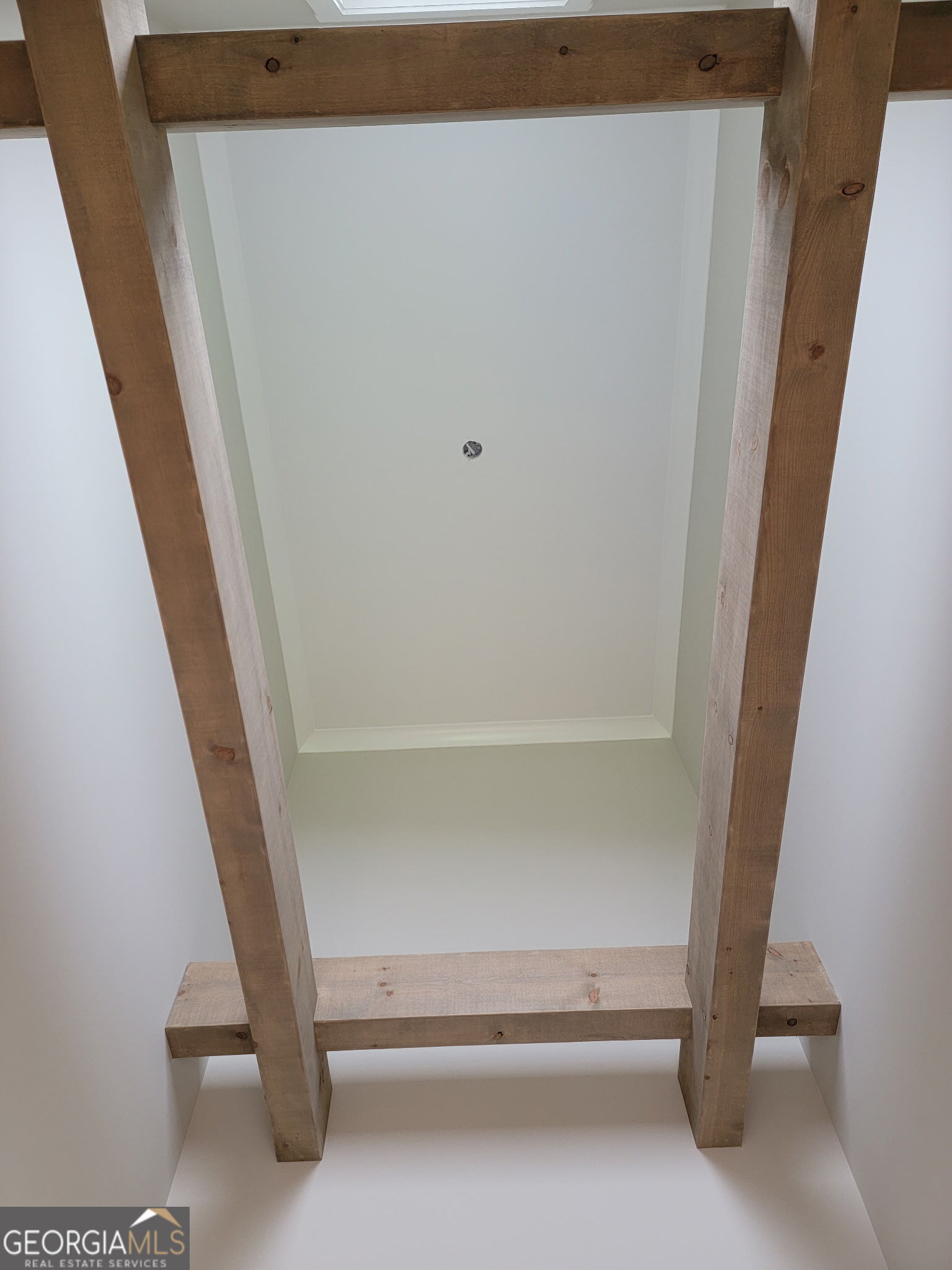 Recessed white ceiling framed by large exposed wood beams.