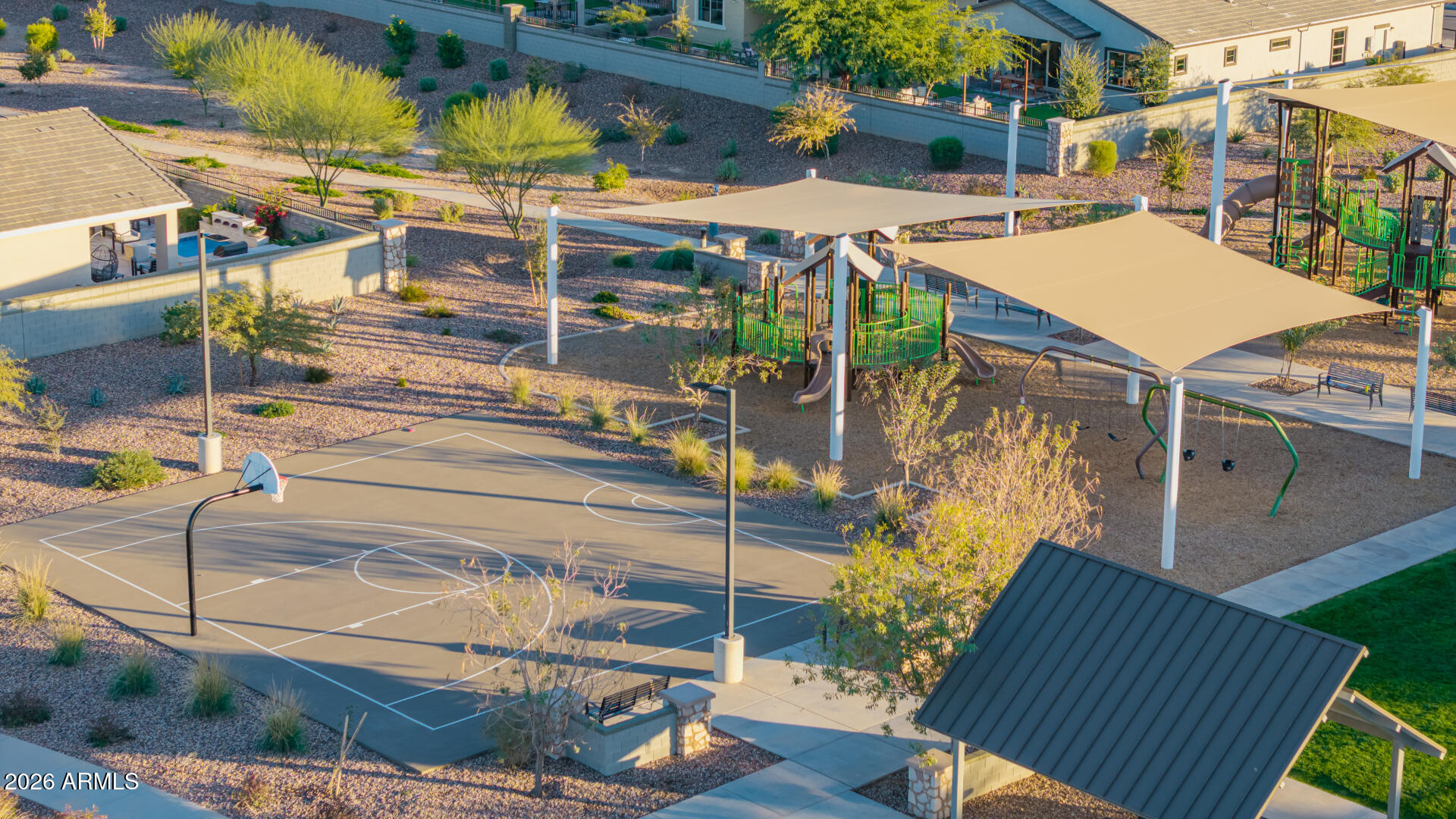 Community recreation area with a basketball court and shaded playground.