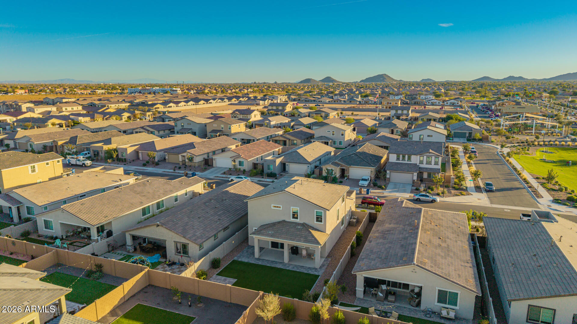 Aerial view of a Queen Creek neighborhood, with the home’s backyard in the foreground and mountains in the distance.