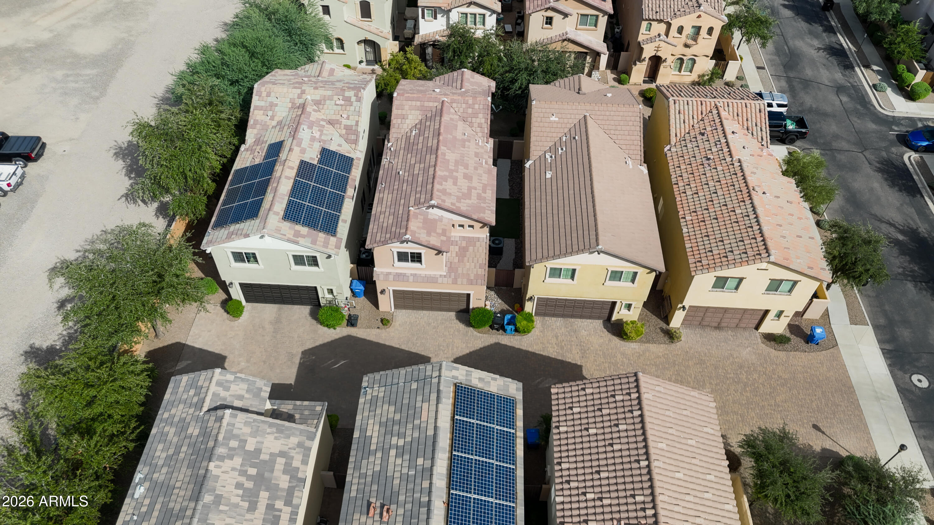 Aerial view of closely spaced homes, including several with rooftop solar panels and attached garages.