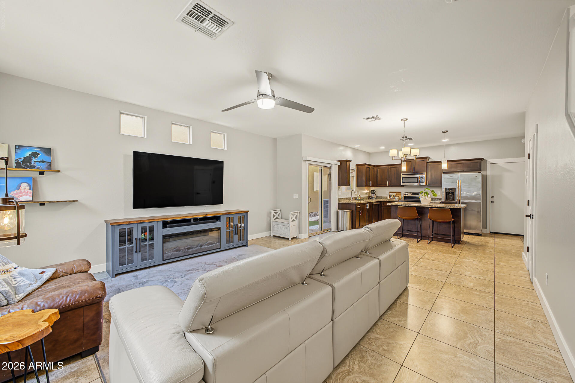 Open-plan living room and kitchen with a large sectional sofa and dark wood cabinetry.