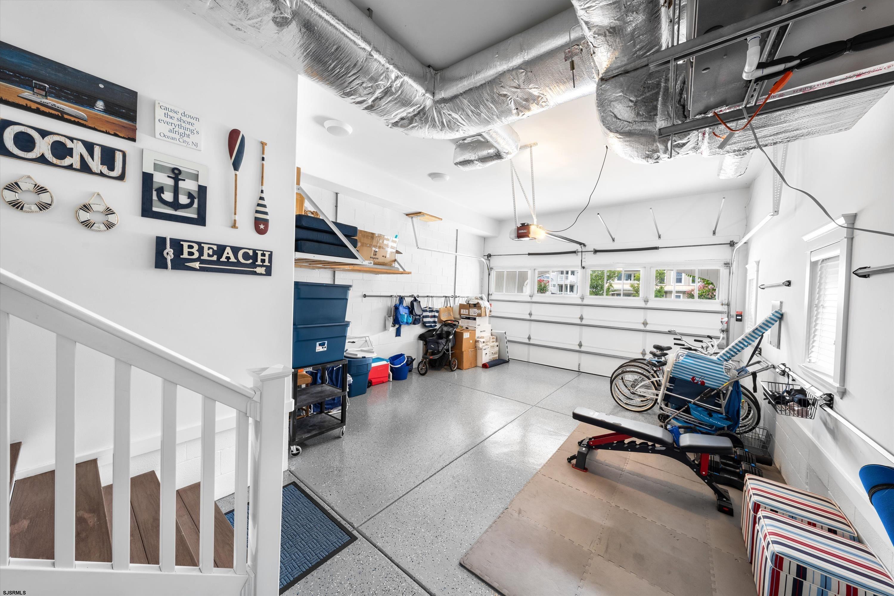 Garage with beach-themed decor, bicycles, storage bins, and exercise equipment.