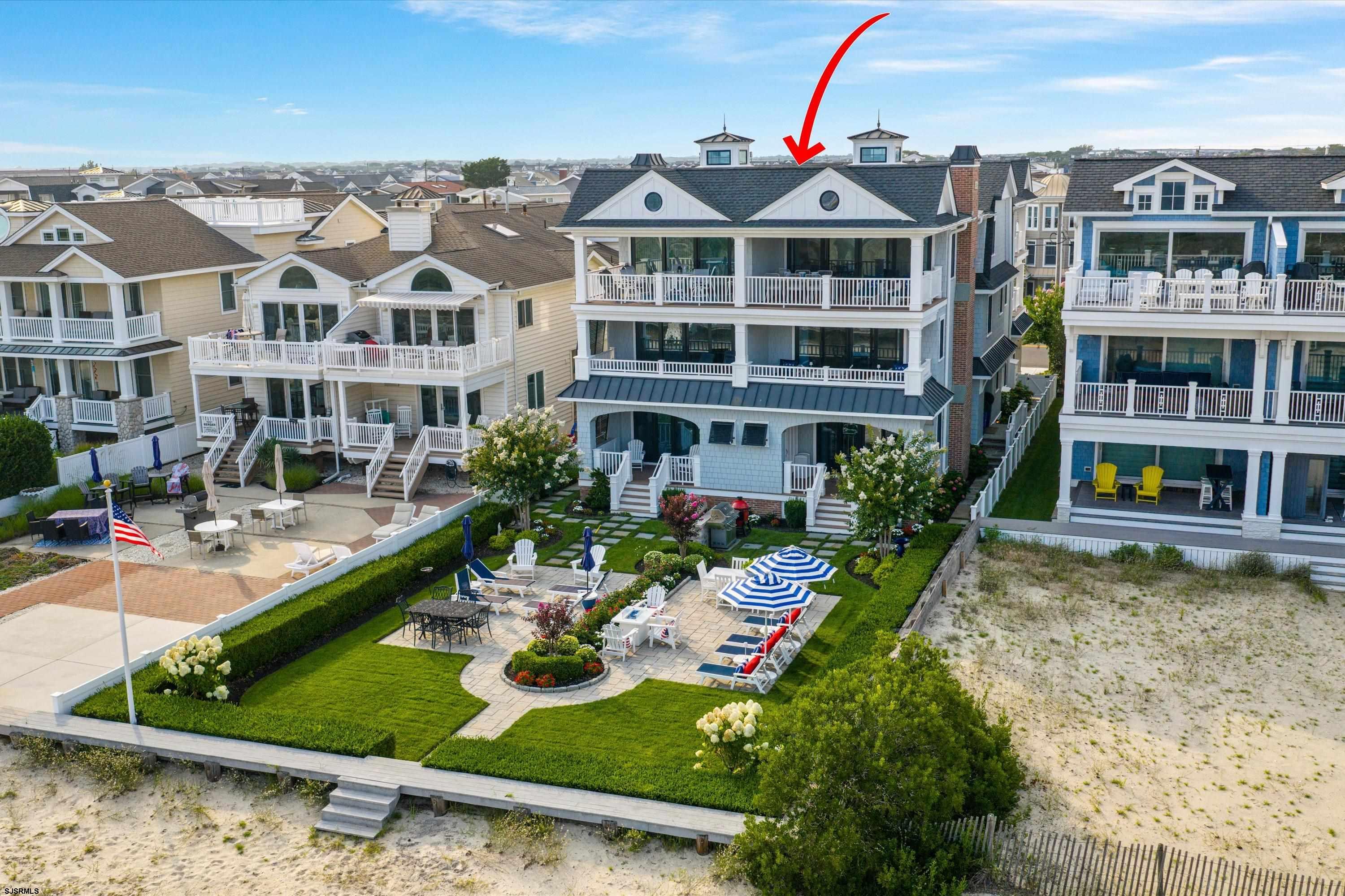 Aerial view of 1913 Wesley Ave North unit, with balconies and landscaped patio beside the beach.