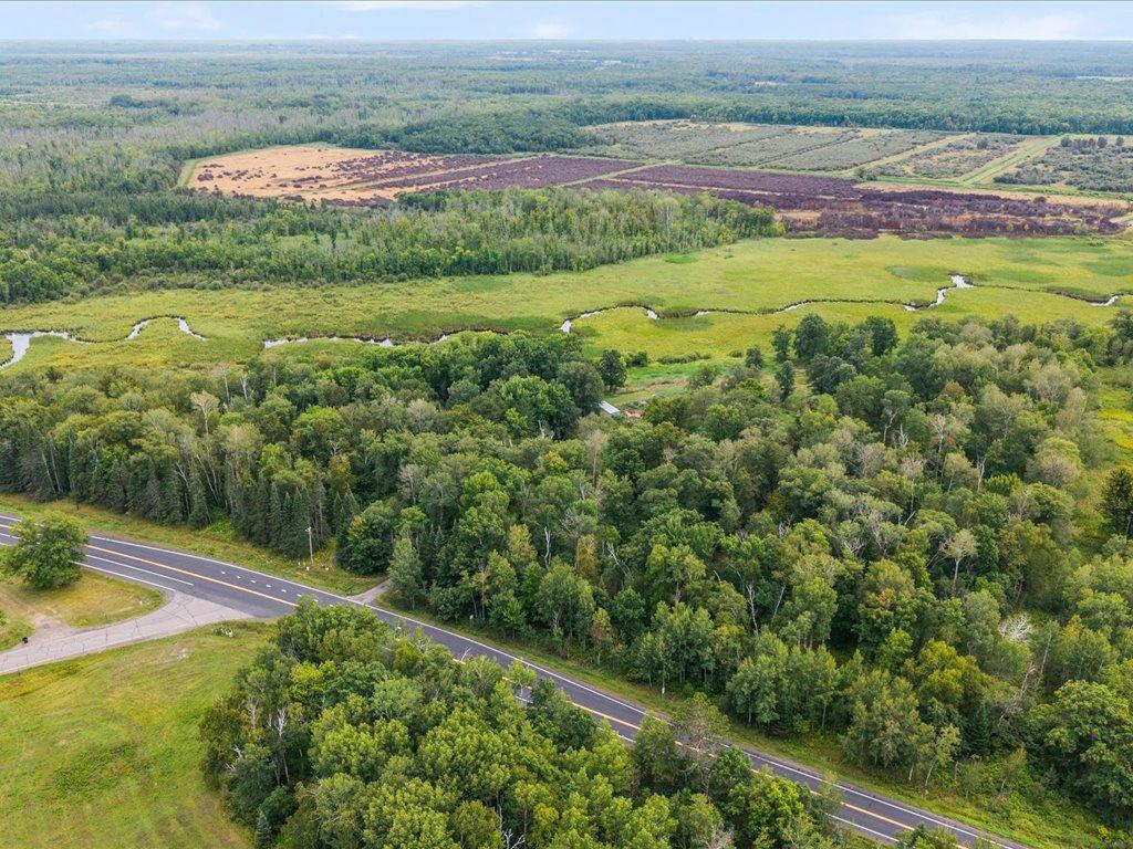 Aerial view of wooded land and wetlands beside State Highway 210.