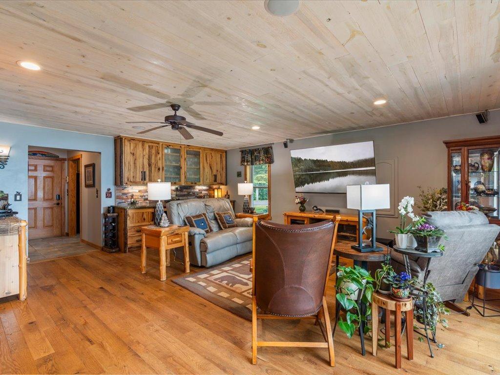 Living room with a pale wood ceiling, rustic cabinetry, and leather and upholstered seating.