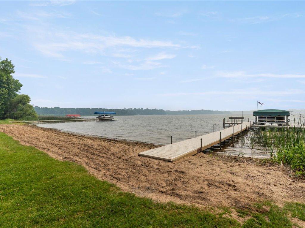 Lakeshore with a long dock and covered boat lifts extending into the water.