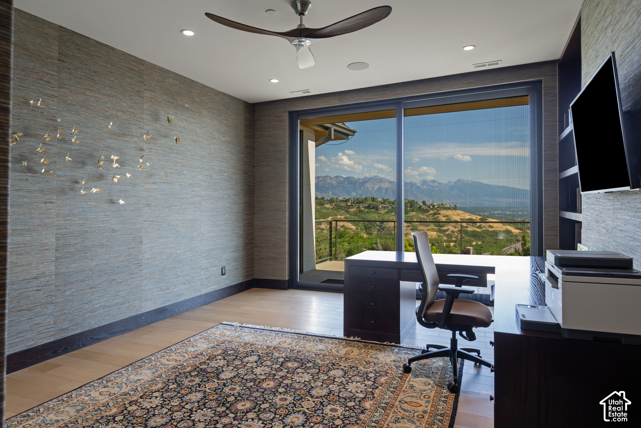 Furnished home office with sliding glass doors framing a mountain and valley view.