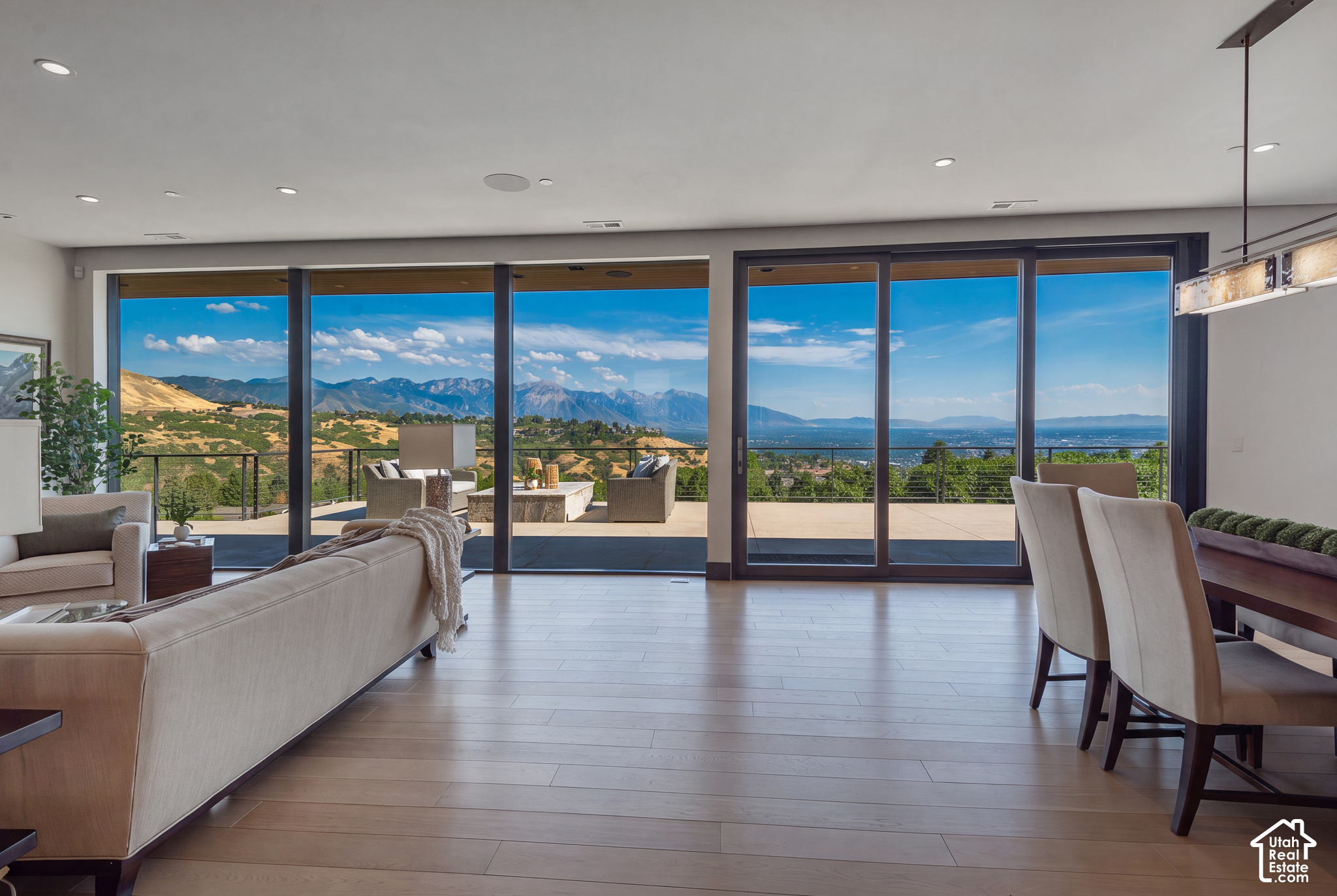 Modern living room with floor-to-ceiling windows overlooking mountains and the city.