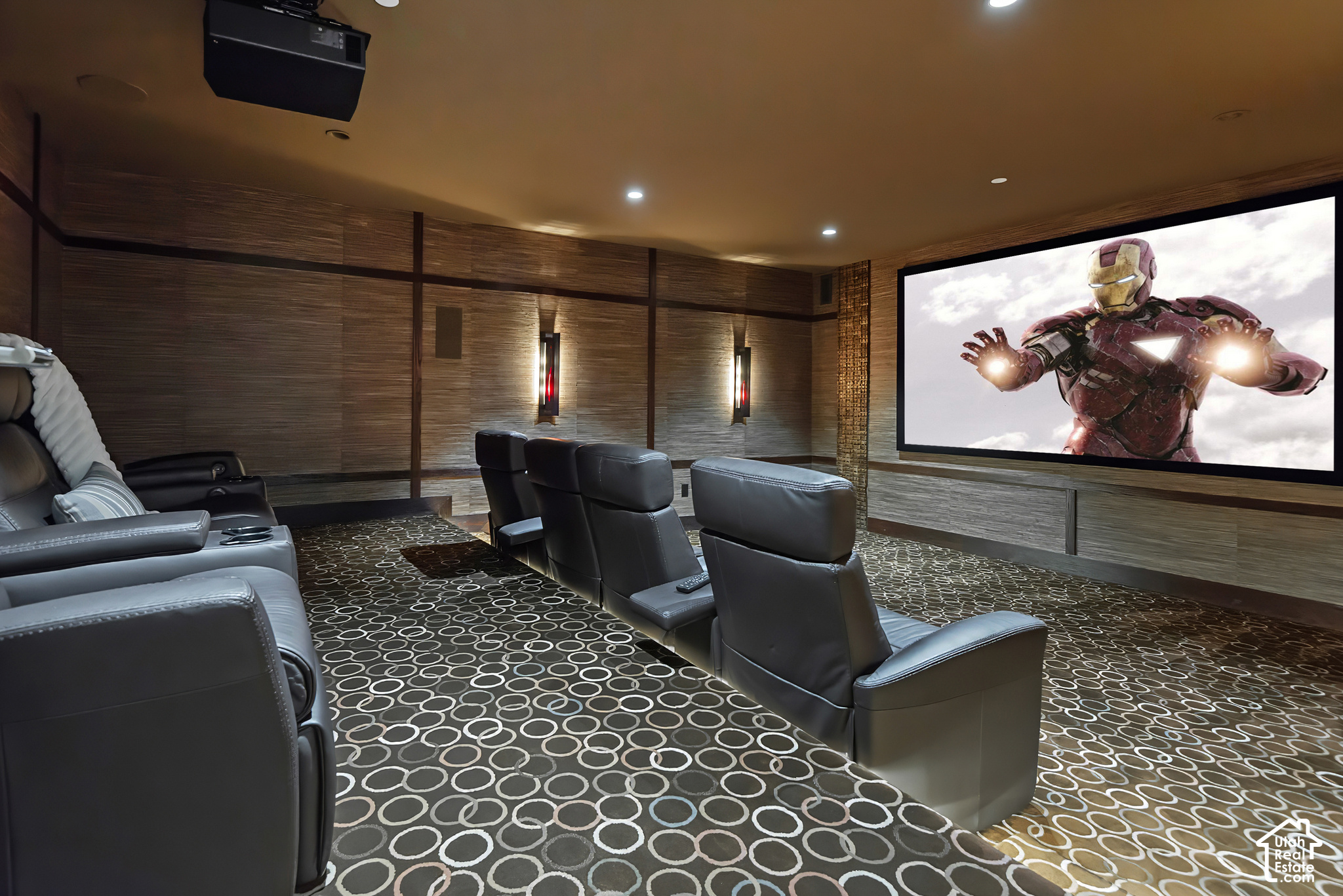 Home theater with black leather recliners, patterned carpet, and a large projection screen.